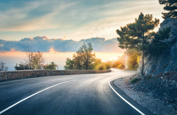 A classic American highway running through a desert landscape at sunset